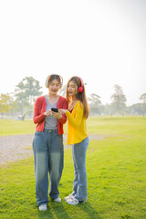 Fototapeta premium Happy Asian woman listening to music and enjoying the music dancing alone outdoors