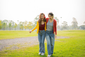 Fototapeta premium Happy Asian woman listening to music outdoors