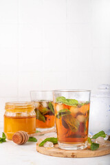Mint and honey iced tea drink, cold summer refreshment cold beverage with a lot of mint leaves, honey and iced cubes, copy space