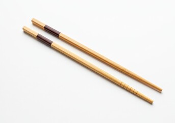 Pair of wooden chopsticks with brown accents arranged diagonally on a clean white background