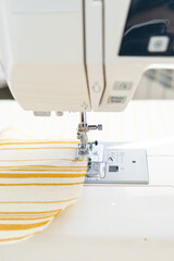 sewing machine with a cloth under a steel needle. manufacture of clothing. a household or industrial sewing machine. tailor, couturier. work on sewing designer clothes.