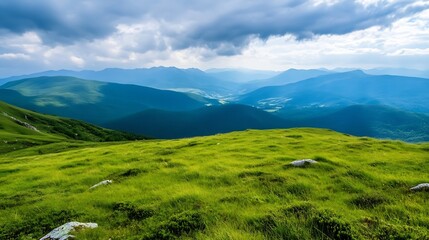 Fototapeta premium Serene vista of rolling green hills and distant blue mountains under a partly cloudy sky, offering a peaceful landscape panorama. : Generative AI