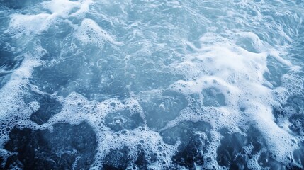 Close-up view of ocean water with white foam and bubbles, creating a textured surface with shades of blue and grey.  The image evokes a sense of calmness and serenity. : Generative AI