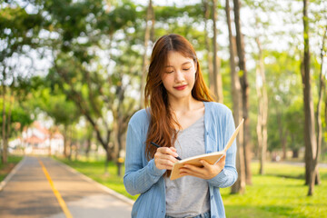  Study of portraits and female students at a university park to learn or study, scholarship books and laptops.