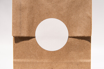 Blank circular sticker on brown paper bag for custom design