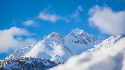 Fototapeta premium Majestic snow-capped mountain peaks rise against a vibrant blue sky, partially obscured by fluffy white clouds, creating a breathtaking winter landscape. : Generative AI