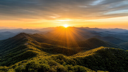 Fototapeta premium Breathtaking sunset over rolling mountains with vibrant orange sky and lush greenery