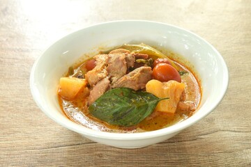 spicy boiled roasted duck meat with pineapple and tomato in coconut milk curry soup on bowl