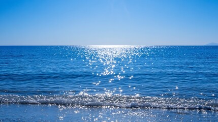 Sparkling ocean waves gently lapping the shore under a vibrant blue sky, sunlight reflecting brilliantly on the water's surface creating a mesmerizing scene of serenity and peace. : Generative AI