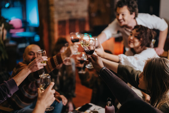 A group of friends gather around for a celebratory dinner, toasting each other.