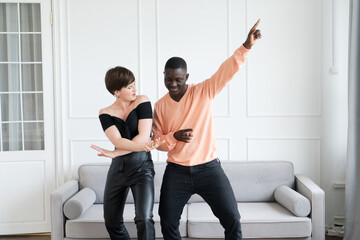 Couple of young man and woman dancing at home