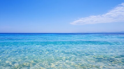 Fototapeta premium Serene turquoise ocean water under a vibrant blue sky, with a distant mountain range barely visible on the horizon. A few fluffy clouds add subtle texture to the otherwise clear sky. : Generative AI