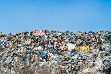 Massive Landfill Mountain: Accumulated Waste and Trash Against Blue Sky, Visualizing Environmental Impact and Pollution Concerns