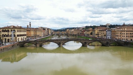 Europe, Italy, Florence , drone aerial view of Florence and Arno river - the Old Bridge , Ponte Vecchio , in city downtown  of the Middle Ages and Renaissance art - Tourist attraction destination 