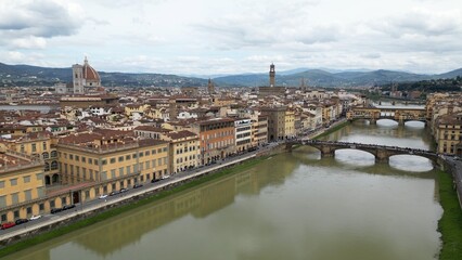 Europe, Italy, Florence , drone aerial view of Florence and Arno river - the Old Bridge , Ponte Vecchio , in city downtown  of the Middle Ages and Renaissance art - Tourist attraction destination 