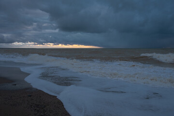 Storm sea sand beach is a neutral color. Natural background in beige shades. The raging elements, the majestic view of the sea surf. Foaming waves roll on the shore. The concept of disaster, threat.
