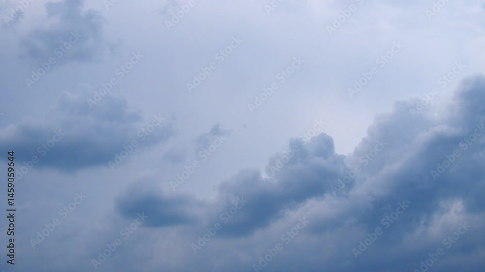 Poster Witness a breathtaking display as fluffy clouds softly drift through the vast sky, painting a tranquil canvas during the enchanting hours of twilight. Nature's artistry unfolds in stunning detail