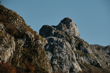 Sharp rocky cliffs and dramatic mountain peaks under clear blue skies in Montenegro wilderness. Rugged natural beauty ideal for hiking, adventure, and nature photography.