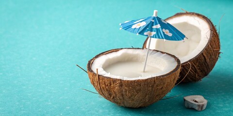 Tropical beach concept made of coconut fruit and sun umbrella. Creative minimal summer idea. Fresh tropical organic juice in summer vibes and relaxation