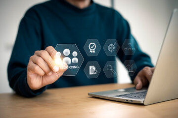 Naklejka premium Outsourcing Global Recruitment Business and internet concept . Business person hand holding outsourcing icon on virtual screen