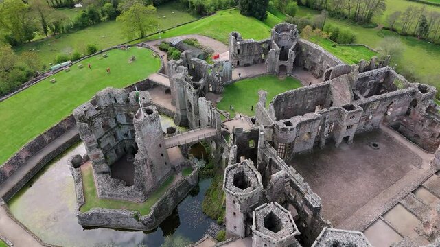 Raglan Castle ruins Wales medieval fortress aerial view farmland fields captured by drone in 4K