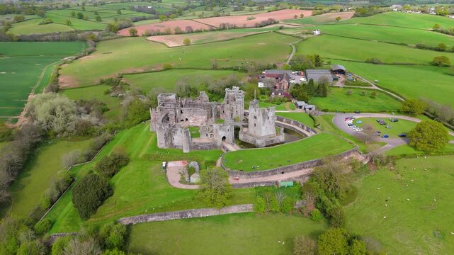 Raglan Castle ruins Wales medieval fortress aerial view farmland fields captured by drone in 4K