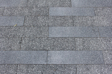 Texture of square paving tile. Pattern of gray sidewalk tiles in the street. Concrete pavers close up background.