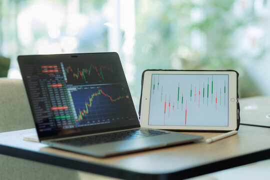 Professional male trader reviewing stock charts and financial data on a laptop in a tech-driven workspace — ideal for fintech, investment, and market analysis.