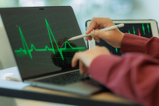 Professional male trader reviewing stock charts and financial data on a laptop in a tech-driven workspace — ideal for fintech, investment, and market analysis.