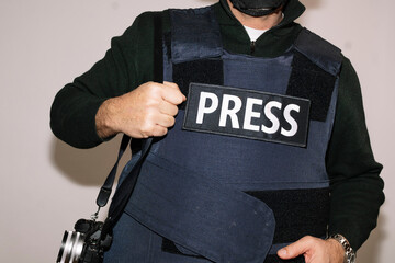 Reporter with bulletproof vest on white background.