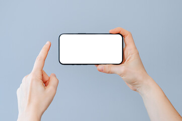 Close up shot of woman typing on mobile phone. Girl hand holding modern smartphone. Blank screen to place your own web page or message.