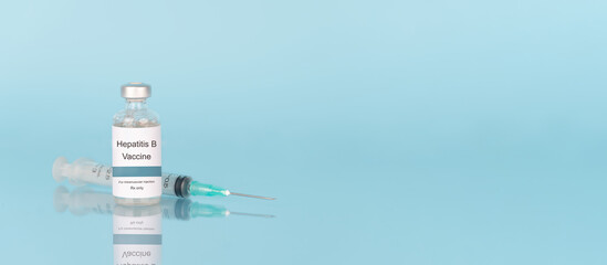 Hepatitis B vaccine vial bottle with syringe on blue background. Hepatitis B vaccine used to...