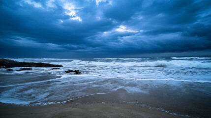 Obraz premium Dramatic ocean waves crashing on a sandy beach under a brooding, dark blue sky. The powerful waves create white foam as they roll onto the shore. : Generative AI