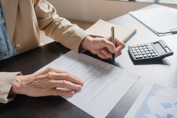 Close up of Mature Caucasian business woman manager working in office, audit analysis graph company...