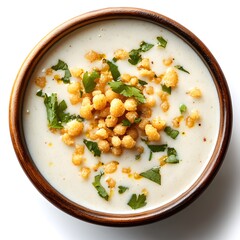 Creamy white soup garnished with crispy fried golden balls and fresh cilantro in a rustic bowl.