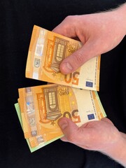 Human hands holding and counting money, cash currency euro. A person pays cash, exchanges, received benefits, salary, invests.