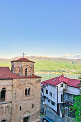 Fototapeta premium Lake Ohrid, North Macedonia, April 13 2024. Mountain range and peninsula in distance. Ohrid Lake, Macedonia, Europe. The clear mesmerizing waters of lake Ohrid with a beautiful view. 