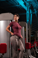 fitness enthusiast showcases her toned physique in stylish gym apparel while standing confidently...