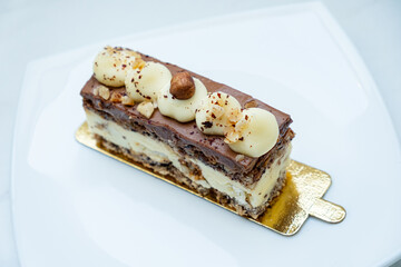 A delicious layered dessert with chocolate, cream, and crunchy nuts awaits at the bakery