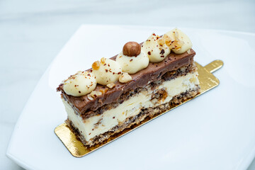 A delicious dessert showcases exquisite layers of chocolate and creamy vanilla, garnished with nuts