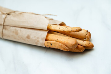 Freshly baked breadsticks bundled in paper, ready to complement a meal and share with friends
