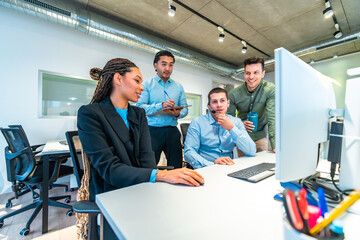 Business team collaborating on computer in modern office