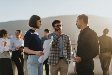 A group of business colleagues stand on a high tower balcony, engaged in creative brainstorming for...