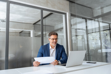 Entrepreneur manager businessman banking analyst doing paperwork analysing using pc. Busy latin...