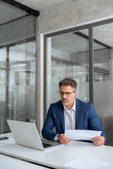Entrepreneur manager businessman banking analyst doing paperwork analysing using pc. Busy latin...