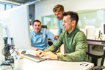 Software developers working together on a computer in office