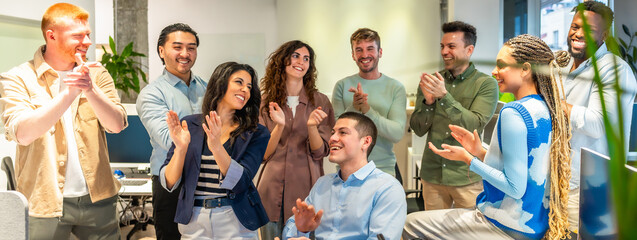 Diverse business team clapping and celebrating success in modern office