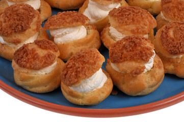 Choux à la crème dans un plat en gros plan sur fond blanc