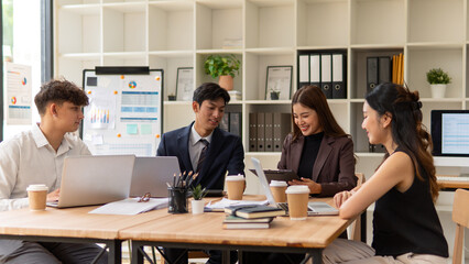 Team of young professionals collaborating on a project discussing ideas during a meeting in a modern office.