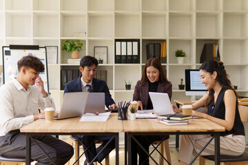 Team of young professionals collaborating on a project discussing ideas during a meeting in a modern office.